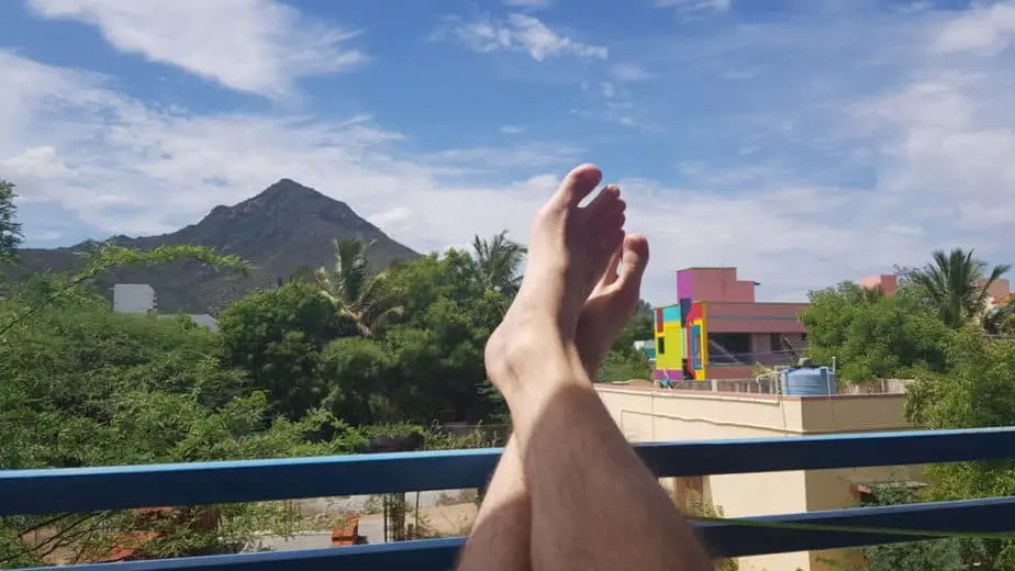 Relaxing with my feet up on the porch of my house, looking at a local mountain