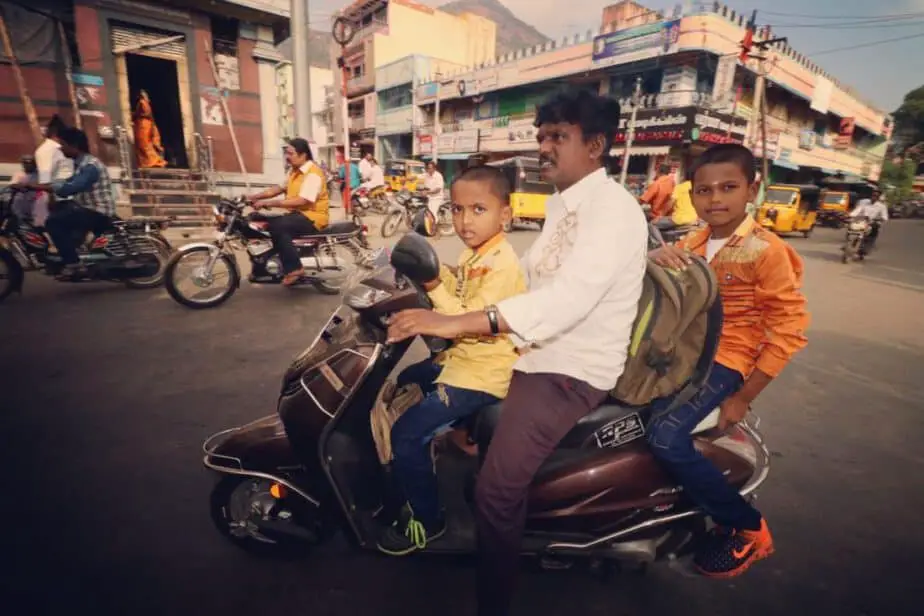 Kids riding a scooter with their dad