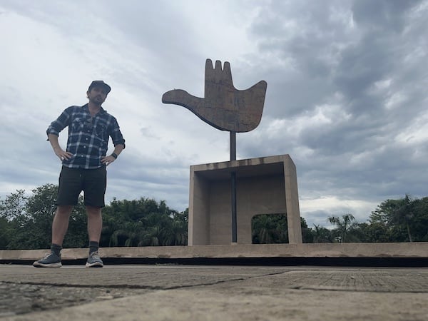 ben jenks standing in chandigarh capitol complex with open hand monument behind