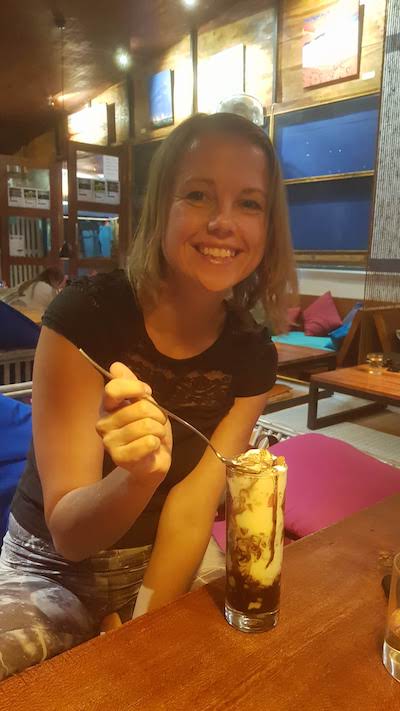tiruvannamali dreaming tree restaurant smiling blond girl eating ice cream in India